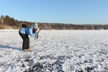 Mavi bir ceket bir tripod ve kamera ile kadında