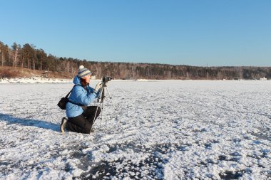 Mavi bir ceket bir tripod ve kamera ile kadında