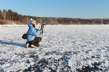 Mavi bir ceket bir tripod ve kamera ile kadında