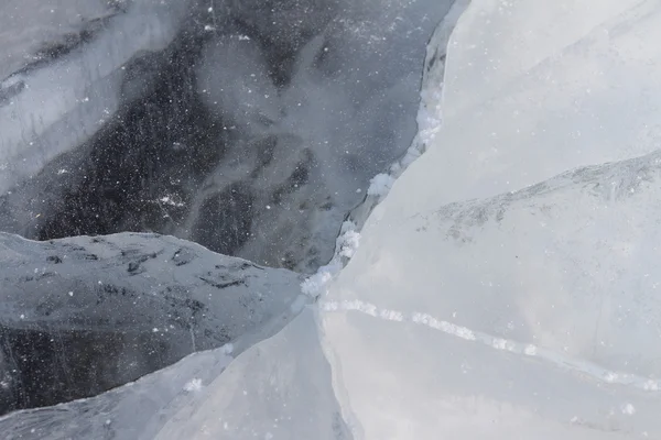 Grieta en una superficie de hielo del río congelado, un trasfondo natural —  Fotos de Stock