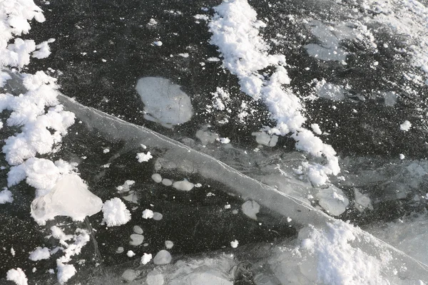 Bolle d'aria e di crepa sotto ghiaccio sul fiume in inverno — Foto Stock