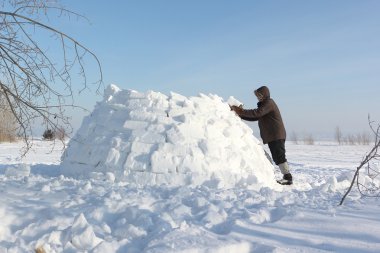 Kışın kar glade üzerinde bir Eskimo Bina adam
