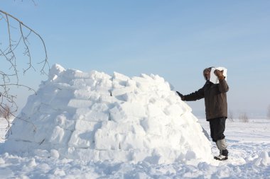 Kışın kar glade üzerinde bir Eskimo Bina adam