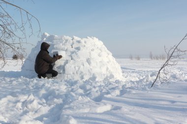 Kışın kar glade üzerinde bir Eskimo Bina adam