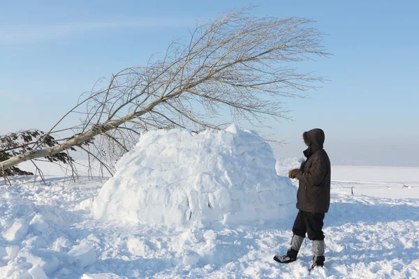 男子在冬天建立在雪林间空地上的一座冰屋 — 图库照片