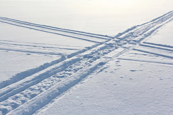 Spuren eines Motorschlittens auf der Schneeoberfläche des Flusses — Stockfoto