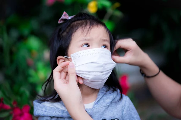 Mão Mãe Está Usando Uma Máscara Médica Para Sua Filha — Fotografia de Stock