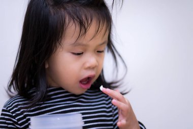 Kız tatlıdan krema karıştırdı ve ağzına koydu. Mutlu çocuk krem tatmak için ağzını açar. Yemek yemeden önce temizlik ve hijyen kavramı. Çocuklar 3 yaşında.. 