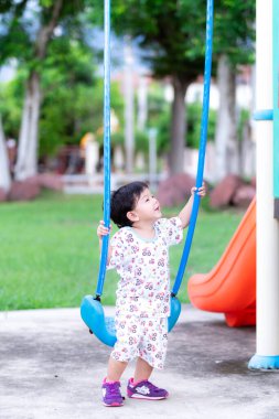Nonthaburi Tayland-6 Haziran 2020: dikey görüntü. Asyalı küçük tatlı oğlan salıncakta sallanıyor.
