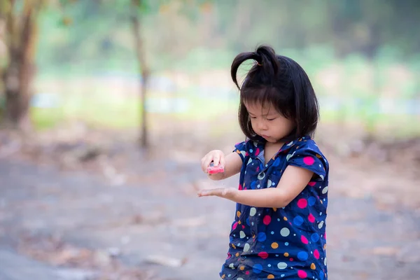 かわいいアジアの子供の女の子は赤いおもちゃの車で遊んでいます 再生から彼女の服に土汚れがあります 田舎で遊んでいる子供 子供は３歳だ — ストック写真