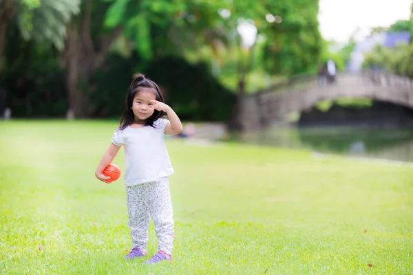 Menina Feliz Jogando Pequena Bola Laranja Grama Verde Com Família — Fotografia de Stock