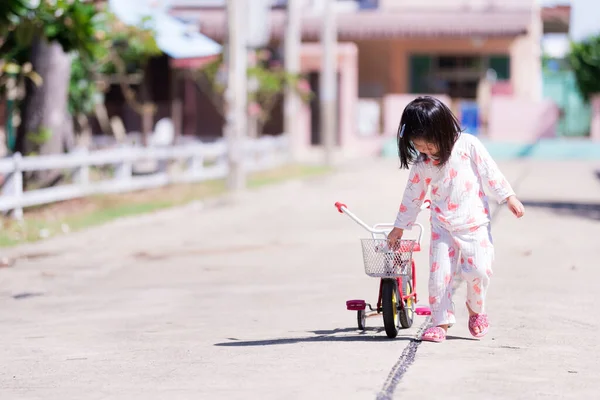 Urocza Azjatycka Dziewczynka Sobie Piżamę Spacerującą Ulicy Dzieci Ciągną Rower — Zdjęcie stockowe