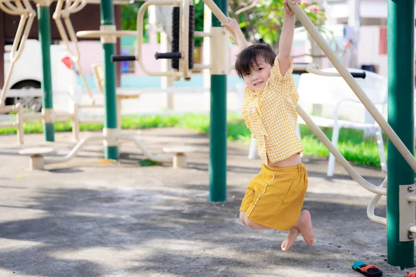 アジアの女の子は運動と健康のためのスポーツを再生します かわいい子供は遊び場で台形でぶら下がって遊ぶのがうれしいです 甘い笑顔の5歳の女の子 — ストック写真