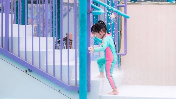 可爱的女孩正在水上公园玩水 她正走上楼去玩滑水游戏 儿童游戏安全概念 可爱的亚洲孩子 身穿泳衣 薄荷绿色 — 图库照片