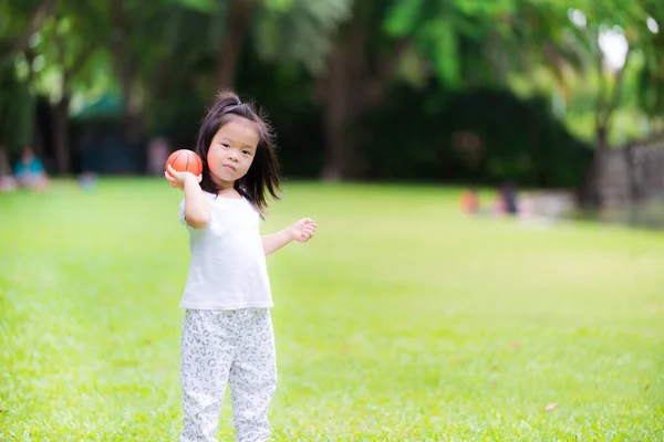 Menina Bonito Jogando Uma Bola Laranja Gramado Verde Menina Asiática — Fotografia de Stock