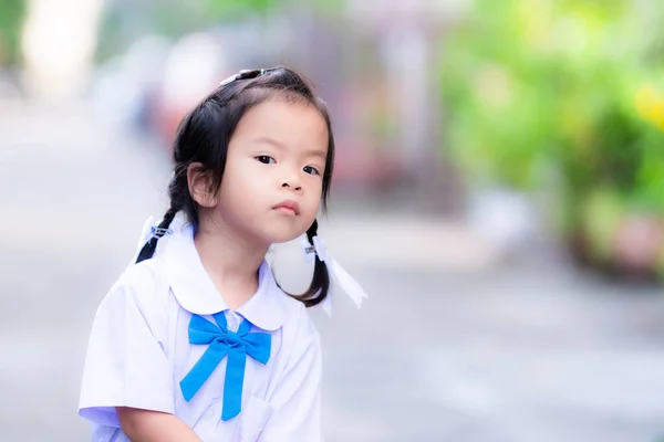 愛らしいアジアの女の子が何かに持ち上げます 女子学生は学校へ行く準備をするのを待っていた 子は3歳 — ストック写真