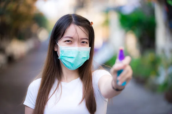 Yeşil Tıbbi Maske Takan Genç Asyalı Kadın Elinde Mavi Sprey — Stok fotoğraf