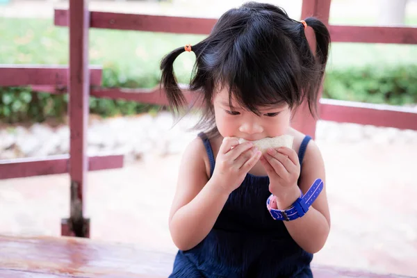 Gadis Asia Yang Manis Sedang Duduk Dan Makan Roti Putih — Stok Foto