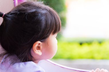 Yeşil doğa manzarasına bakan sevimli bir kızın yan görüntüsü Mutlu çocuklar, yalnız çocuklar, yalnız çocuklar doğayı takdir ederler.