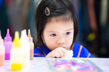 Kız pişmanlık içinde başını eğip oturdu. Elindeki mendil gözyaşlarını silmek için kullanılıyordu. Çocuk işi zarar gördüğü için üzgün. Hatalardan ders al. Çocuklar sanat yapar. 3-4 yaşlarındaki çocuklar..