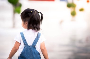 Küçük kızın geçmişe bakışı tulum giyiyor. O, tapınağın etrafında yürüyor. Kız 2 yaşında..