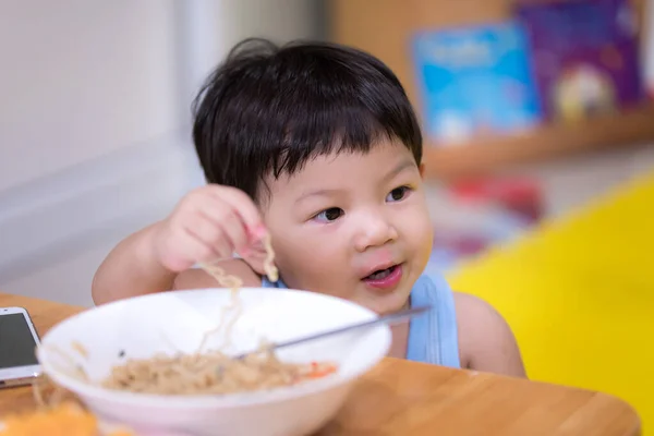 お腹が空いたら手を使って食べます 曇りの日に 子供は即席の麺を食べる 2歳の少年 — ストック写真