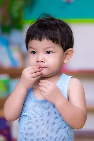 食べ物を食べるために彼の手で肖像画アジアの少年空腹 曇りの日には家にいなさい 青いタンクの上を身に着けている2歳の幼児 夏には — ストック写真