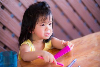 Küçük çocuklar evde kitap yazmaktan bıktılar. Gözyaşları içinde oturan kız, Corona 2019 zatürree salgınında takılmak istiyor. Anaokulu kavramına evde ve sosyal mesafede kalın.