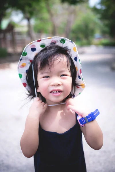 스러운 아시아인 아이가 오후의 길가에 있습니다 그녀는 아름다운 얼굴을 모자를 — 스톡 사진