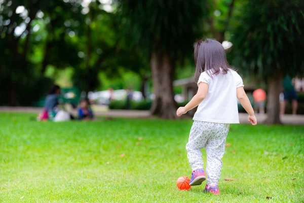Gadis Itu Menendang Bola Oranye Kecil Dengan Kaki Kirinya Saat — Stok Foto
