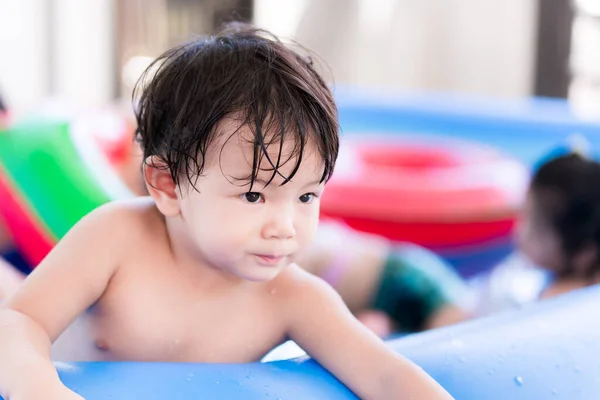 小男孩在房子前面的蓝色游泳池里玩耍 用水浸湿你的整个身体 在夏天的健康和幼儿的活动 孩子才2岁 — 图库照片