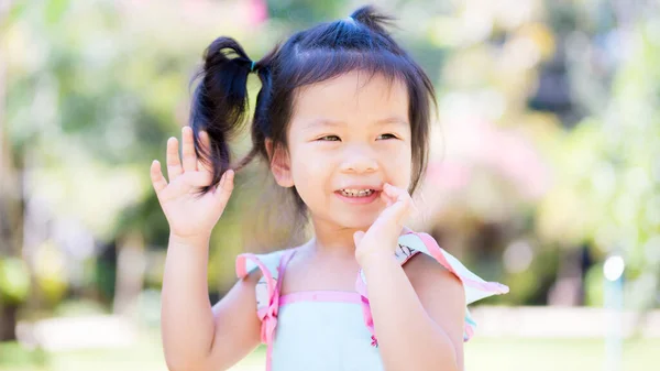 公園を走っている幸せなアジアの女の子がいた 子供は甘い笑顔をしています 子供たちはミントグリーンのシャツを着ている 子供はミルクの歯を王冠 赤ちゃんは３歳です — ストック写真