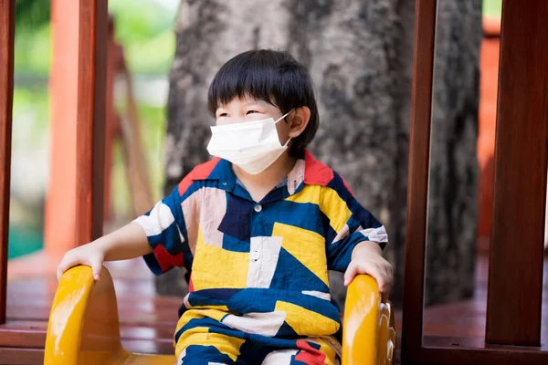 Boy Wearing White Face Mask Playing Yellow Slide Dexterous Child — Φωτογραφία Αρχείου