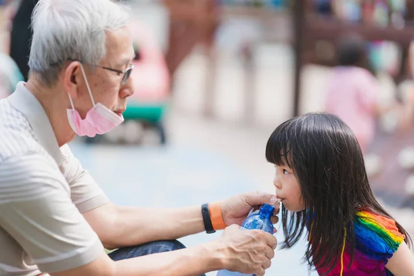 Fokus Selektif Anak Kakek Memegang Botol Air Untuk Cucu Perempuan — Stok Foto