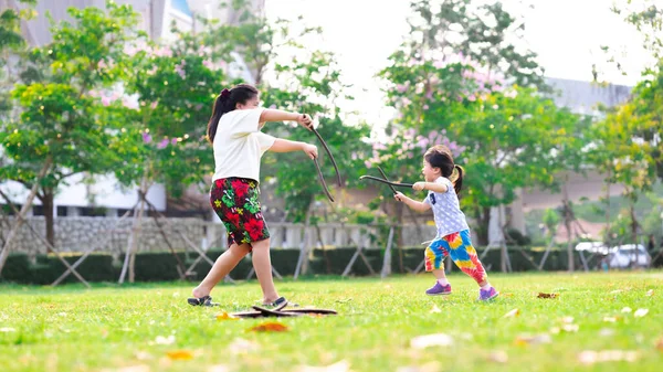 어머니와 잔디에서 있었다 가족들은 재미로 싸운다 아시아 산귀여운 소녀는 뛰면서 — 스톡 사진
