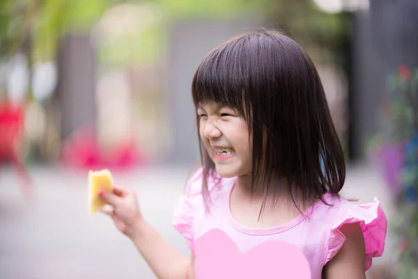 アジアのかわいい女の子の笑顔と果物を食べながら笑っての肖像画 熟したマンゴーを持っている子供 ピンクのシャツを着た幸せな子供 5歳から6歳の子供 — ストック写真