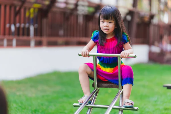 Anak Asia Dengan Gaun Berwarna Warni Bermain Jungkat Jungkit Lapangan — Stok Foto