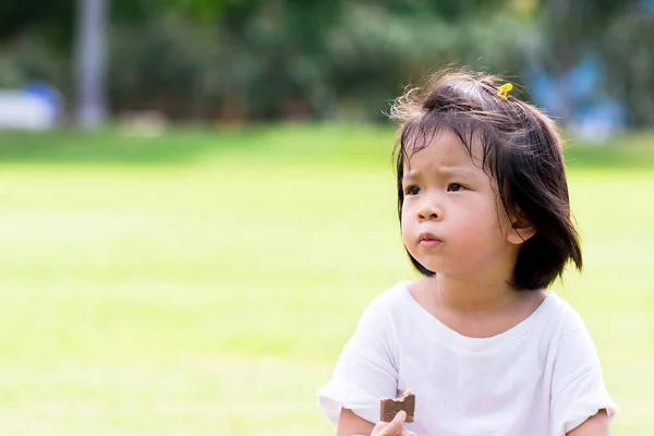 Asiatiska Barn Äter Choklad Plattor Naturliga Gröna Lagar Bakgrund Söt — Stockfoto