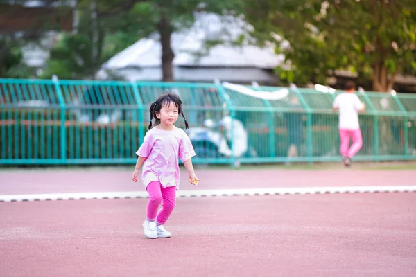 귀여운 아시아인 경기장에서 조깅하고 아이들은 티셔츠와 레깅스를 운동화를 신습니다 아이는 — 스톡 사진