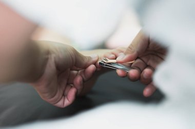 Anne kızın ayak tırnaklarını kesiyor..