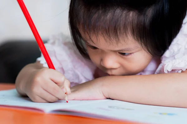 집에서 미취학 귀엽군 아시아 아이들은 크레용을 빨간색으로칠 합니다 아이는 가까이에 — 스톡 사진