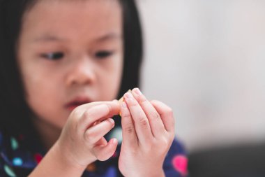 Seçici Odaklanma. Öğrenci kız, sanatları için kullanılacak parçalara kasıtlı olarak çift taraflı bant yapıştırıyor..