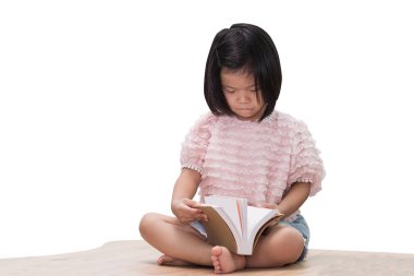 Asyalı kız çocuğu ahşap masada ders kitabını tutuyor ve okuyor. Öğrenmek asla kavramları bitirmez. İzole edilmiş beyaz arkaplan.