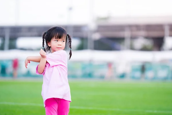 緑の草の背景にアクティブな幼稚園の女の子の運動 スポーツの子 健康のための演習 5歳の子供 — ストック写真
