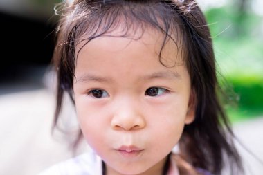 Düşünceli ve meraklı bir ifadeyle genç bir kızın sanatsal yakın plan portresi. Yumuşak doğal aydınlatma gözlerini ve masum özelliklerini vurguluyor. Çocukluk duyguları ve farkındalık kavramı.