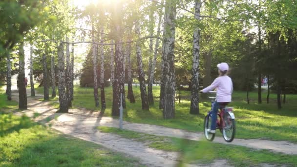 Παιδί βόλτες με ένα ποδήλατο στο πάρκο — Αρχείο Βίντεο