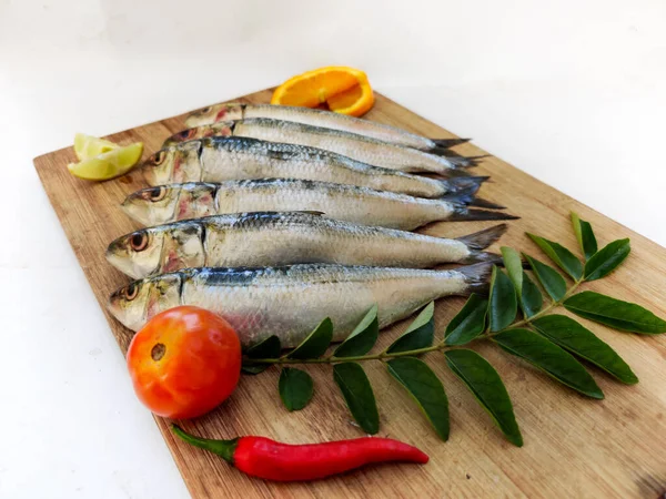 Ahşap bir zeminde otlar ve sebzelerle süslenmiş Hint yağı manzarası..