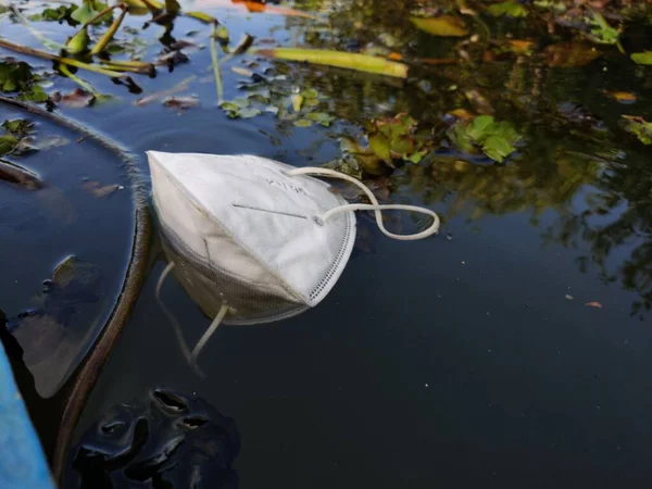 After effect of COVID, N 95 face mask floating on the surface of water,water pollution concept. Selective focus.