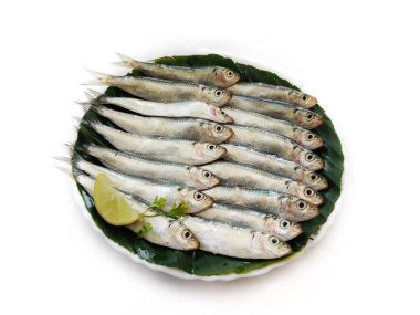 Closeup view of Fresh Indian oil Sardine decorated with herbs and vegetables,Selective focus.White Background. clipart