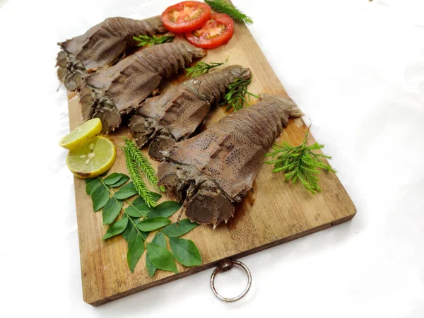 Taze Kum Istakozu ya da Yassı Kafa Istakozu ya da Terlik Istakozu (Thenus Orientalis) otlar ve sebzelerle süslenmiş tahta bir çayırda. Beyaz Arkaplan, Seçici Odak.